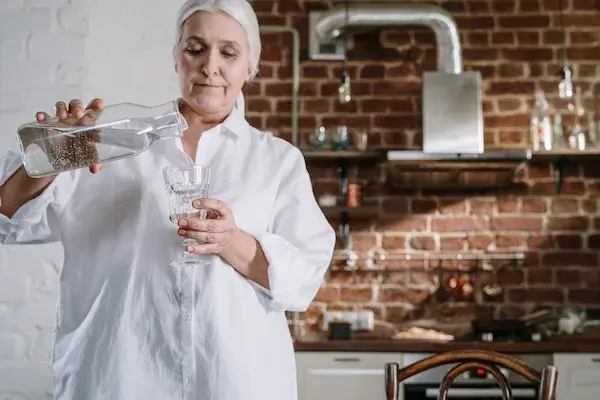 alkaline water filter person pouring water in a glass